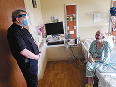 Fr. Pat Norris, OP, chaplain at SSM Health St. Mary’s Hospital in Madison, visits with patient Tom Donahue of Madison. (Photo courtesy of SSM Health St. Mary's Hospital)