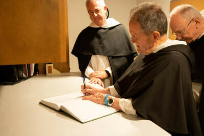 Frs. Marchionda, Morrone, and Wright signing the book of the newly professed.