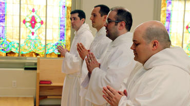 Brothers praying during the ordination