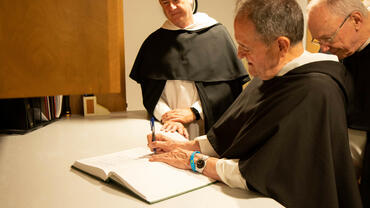Frs. Marchionda, Morrone, and Wright signing the book of the newly professed.