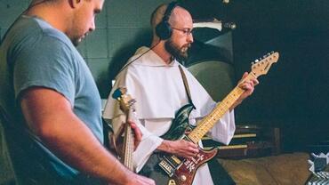 Fr. Zuelke playing guitar